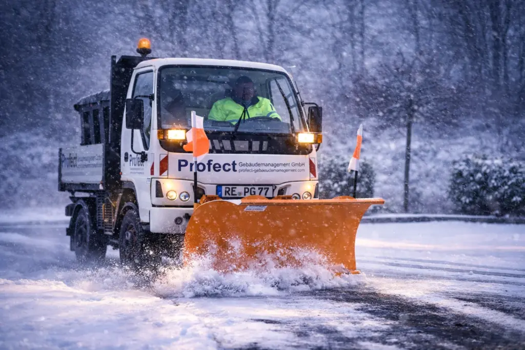 Winterdienstfahrzeug von Profect räumt Schnee auf einer Zufahrt